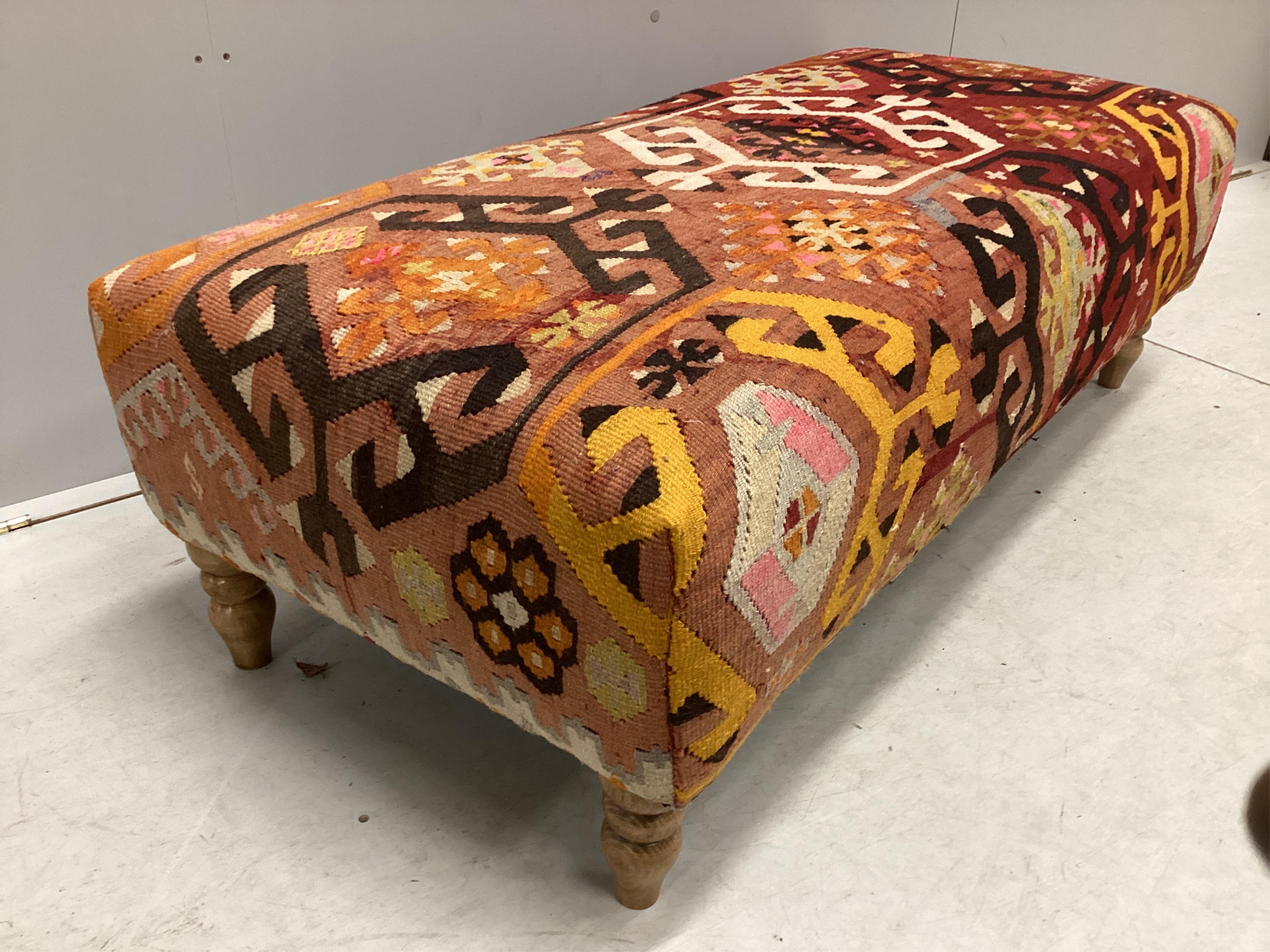 A large contemporary rectangular footstool with antique polychrome Kilim upholstery on turned beech feet, width 126cm, depth 58cm, height 40cm. Condition - good